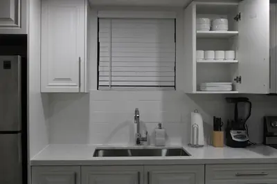 a kitchen with a sink and white cabinets at Comfyhome in Vaughan