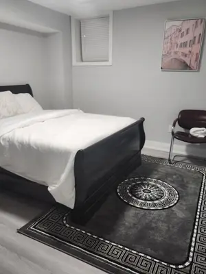 a bedroom with a bed with a rug and a chair at SUITE A 2 Bedroom Apartment in Brampton
