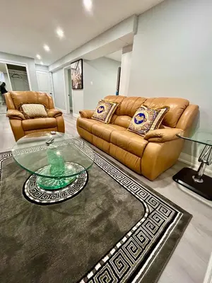 a living room with two couches and a glass table at SUITE A 2 Bedroom Apartment in Brampton