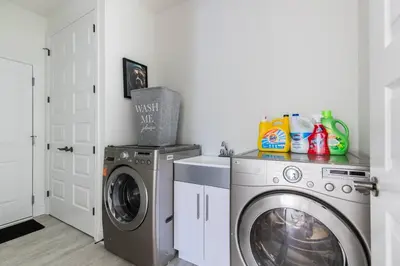 a laundry room with a washing machine and a washer at Comfortable Lux, Sleeps 10, PingPong, Movie Room in London