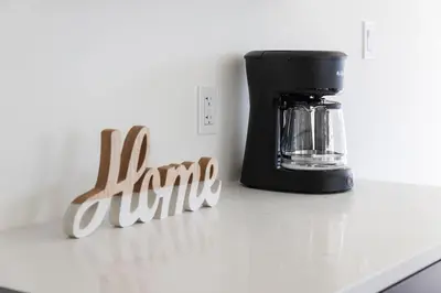 a black coffee maker on a counter next to a sign at Comfortable Lux, Sleeps 10, PingPong, Movie Room in London