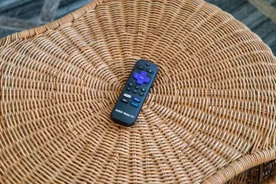 a remote control sitting on top of a wicker chair at Comfortable Lux, Sleeps 10, PingPong, Movie Room in London