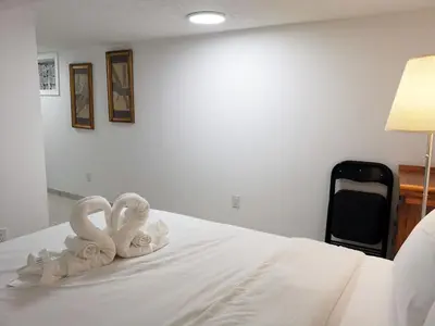two towel swans sitting on top of a bed at Tidy Private Rooms with Full Kitchen in Toronto