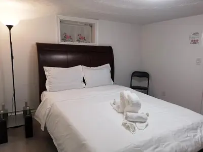 a bedroom with a bed with towels on it at Tidy Private Rooms with Full Kitchen in Toronto