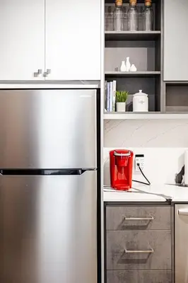 a kitchen with a stainless steel refrigerator with a red appliance at Downtown Oasis-2BR-Spa Bath-Pet Friendly, Free Parking in Toronto