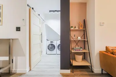 a hallway with a white door and a washing machine at Downtown Oasis-2BR-Spa Bath-Pet Friendly, Free Parking in Toronto