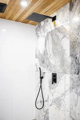 a shower in a bathroom with a marble wall at Downtown Oasis-2BR-Spa Bath-Pet Friendly, Free Parking in Toronto