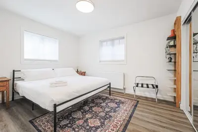 a white bedroom with a bed and a rug at Downtown Oasis-2BR-Spa Bath-Pet Friendly, Free Parking in Toronto