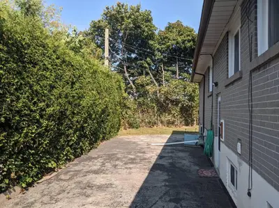 a driveway of a house next to a building at Cozy basement apartment in the heart of Oakville in Oakville