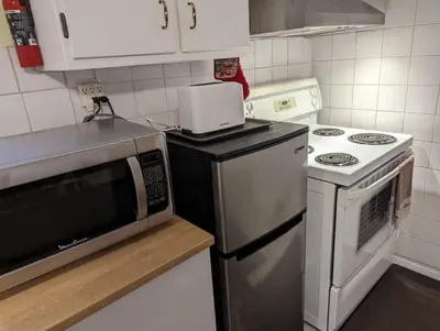 a kitchen with a microwave and a stove top oven at Cozy basement apartment in the heart of Oakville in Oakville