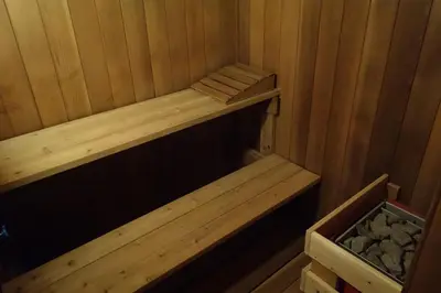 a wooden sauna with a wooden shelf and a box at The Nest in the Forest Bed and Breakfast (Hot tub and Sauna) in Lakefield