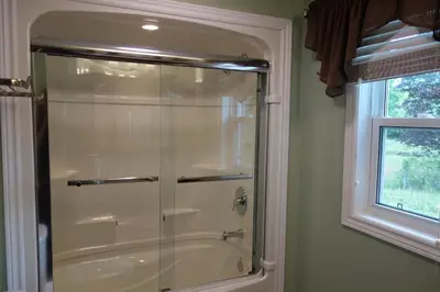 a glass shower in a bathroom with a window at The Nest in the Forest Bed and Breakfast (Hot tub and Sauna) in Lakefield