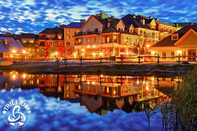 a group of houses at night with a reflection in the water at Mountainview Loft at North Creek Resort in Blue Mountains