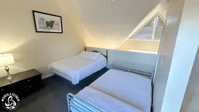 a small room with two beds and a window at Mountainview Loft at North Creek Resort in Blue Mountains
