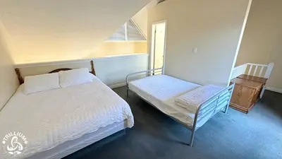 a bedroom with a bed and a chair and a window at Mountainview Loft at North Creek Resort in Blue Mountains