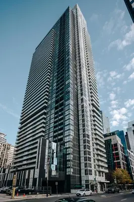 a large tall building with cars parked in front of it at The Vine & View Suite in Toronto
