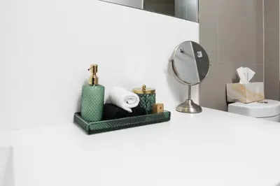 a bathroom with a mirror and towels on a counter at The Vine & View Suite in Toronto