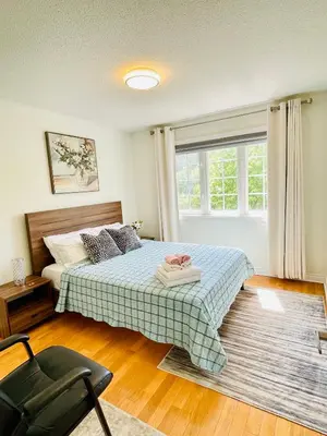 a bedroom with a bed and a chair and a window at Homestay- private room and bathroom in Whitby