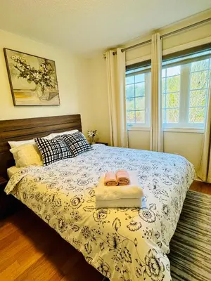 a bedroom with a bed with a blue and white comforter at Homestay- private room and bathroom in Whitby