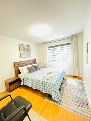 a bedroom with a bed and a chair and a window at Homestay- private room and bathroom in Whitby