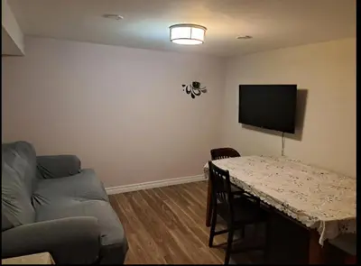 a living room with a table and a couch at Cozy room near Pickering OPG in Pickering