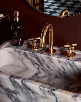 a bathroom sink with two faucets and a mirror at Hotel Julie in Stratford