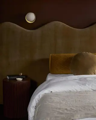 a bedroom with a bed with a large headboard at Hotel Julie in Stratford