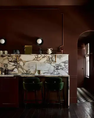 a kitchen with a marble counter and two green bar stools at Hotel Julie in Stratford