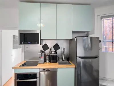 a kitchen with white cabinets and a stainless steel refrigerator at Cozy 2 Bedroom 2 Bathroom with Parking in Toronto
