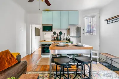 a kitchen with a table and two stools in a room at Cozy 2 Bedroom 2 Bathroom with Parking in Toronto