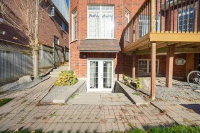 a brick building with a white door in front at Cozy Lovely Ravine facing Suite. in Mississauga