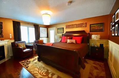 a bedroom with a large bed and a chair at Explorer House Bed & Breakfast in Niagara on the Lake