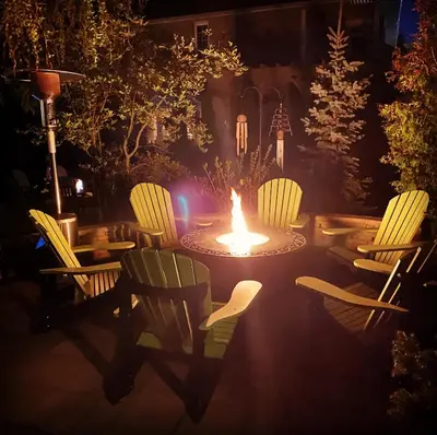 a firepit with chairs and a table with a fire burns at Explorer House Bed & Breakfast in Niagara on the Lake