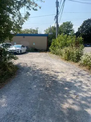 a parking lot with a car parked in front of a building at Downtown apartment 2-3 people in Bowmanville