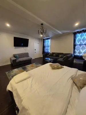 a living room with a large bed and a couch at Downtown apartment 2-3 people in Bowmanville