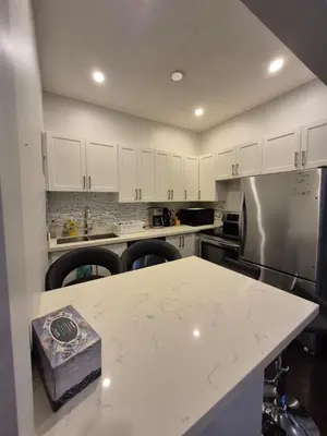 a kitchen with white cabinets and a white counter top at Downtown apartment 2-3 people in Bowmanville