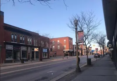an empty city street with buildings and a street light at Downtown apartment 2-3 people in Bowmanville