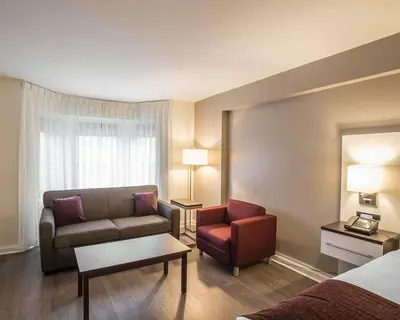 a hotel room with a couch and a chair at The Saint James Hotel, an Ascend Collection Hotel in Toronto