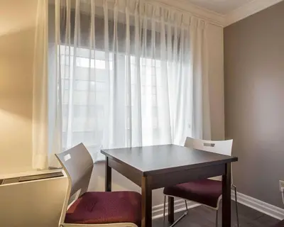 a dining room table with two chairs and a window at The Saint James Hotel, an Ascend Collection Hotel in Toronto