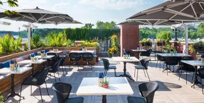 an outdoor patio with tables and chairs and umbrellas at The Saint James Hotel, an Ascend Collection Hotel in Toronto