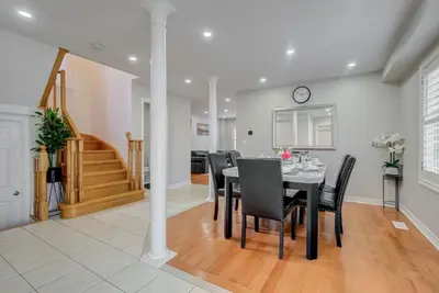 a dining room with a table and black chairs at 4-BR Family Haven - Near Wonderland and Vaughan Mills in Vaughan