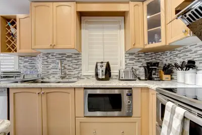 a kitchen with wooden cabinets and a microwave at 4-BR Family Haven - Near Wonderland and Vaughan Mills in Vaughan