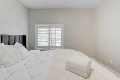 a white bedroom with a large white bed with a window at 4-BR Family Haven - Near Wonderland and Vaughan Mills in Vaughan