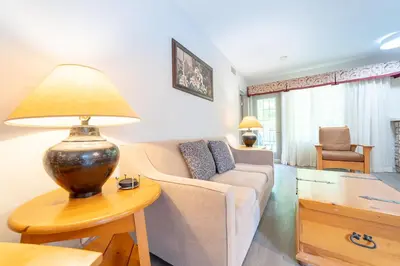 a living room with a couch and a lamp on a table at Horseshoe Valley Suites - The Evergreen in Shanty Bay