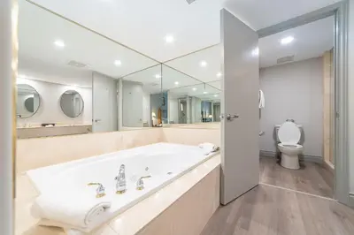 a white bathroom with a tub and a toilet at Horseshoe Valley Suites - The Evergreen in Shanty Bay