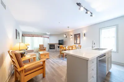 a kitchen and living room with a table and chairs at Horseshoe Valley Suites - The Evergreen in Shanty Bay