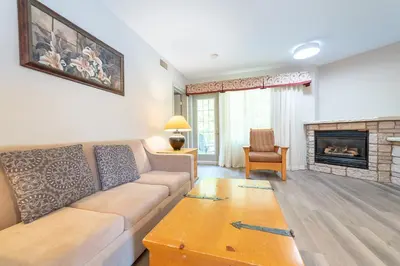 a living room with a couch and a fireplace at Horseshoe Valley Suites - The Evergreen in Shanty Bay