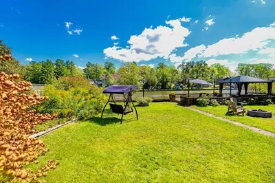 a picnic table in the grass in a park at Charming riverside cottage, walk to beach in Wasaga Beach