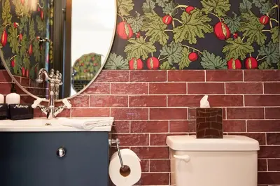 a bathroom with a toilet and a sink and a mirror at The Dorchester Hotel in Collingwood