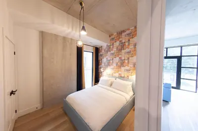 a bedroom with a bed and a brick wall at The Laundry Rooms Augusta in Hamilton